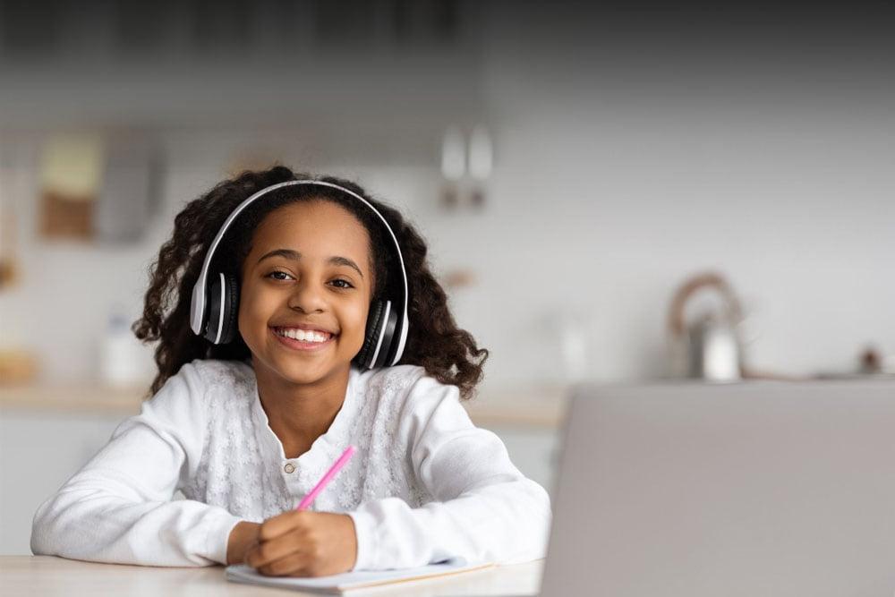 Young student in a white shirt studying during online classes at Tennessee Connections Academy